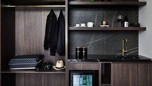 A modern kitchen with dark wood cabinetry, a marble backsplash, and a built-in refrigerator. - Crowne Plaza Sydney Burwood by IHG (Burwood)