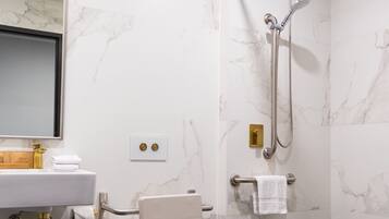 A modern bathroom with a toilet, sink, and shower.