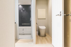 A modern bathroom with a glass-enclosed shower, a toilet, and a wooden floor. - Hotel Yae no Midori Tokyo (Tokyo)