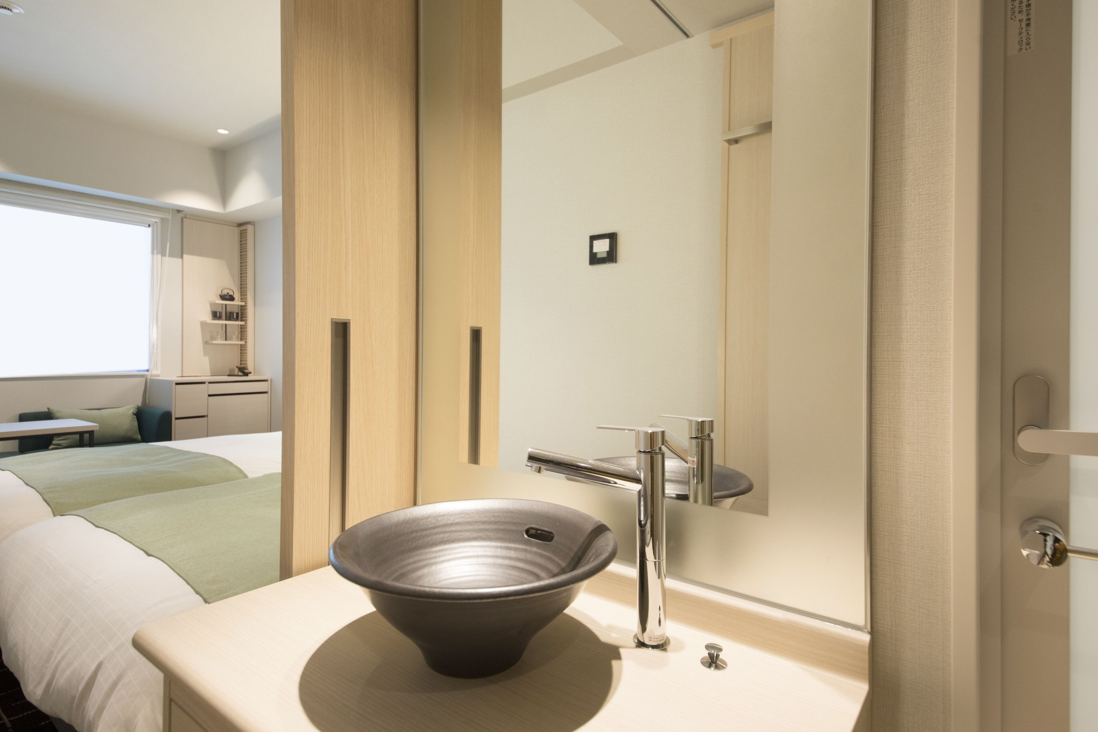 Une salle de bain moderne dotée d’un grand miroir, d’un lavabo sur colonne et d’un design minimaliste.
