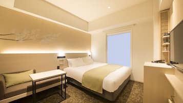 Una habitación de hotel moderna con una cama grande, un escritorio, una silla y un televisor.