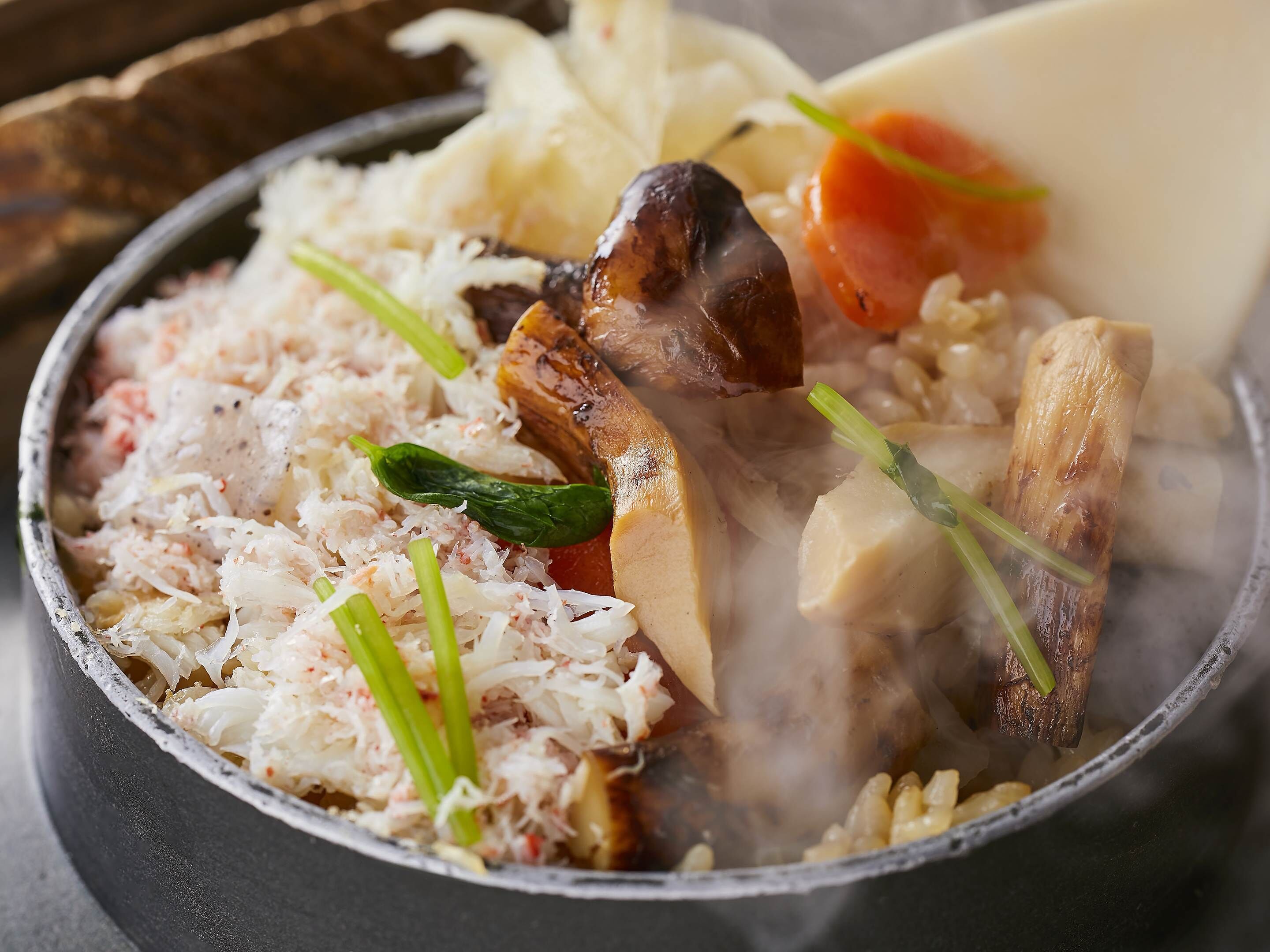 Un bol d'aliments amb diversos ingredients, com ara arròs, verdures i possiblement carn.