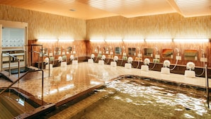 Un baño público con varios lavamanos, espejos y piso de baldosas.