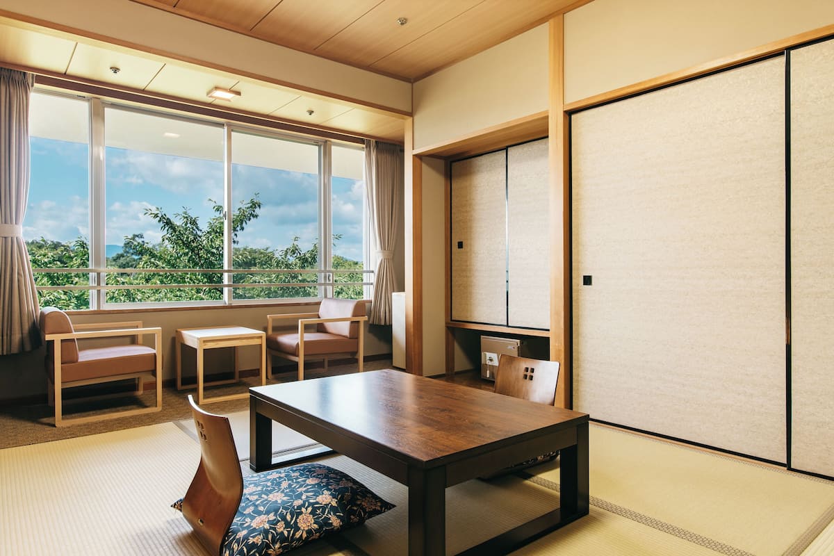 Une pièce de style japonais traditionnel, avec un sol recouvert de tatamis, une petite table en bois et un paravent coulissant de type shoji.