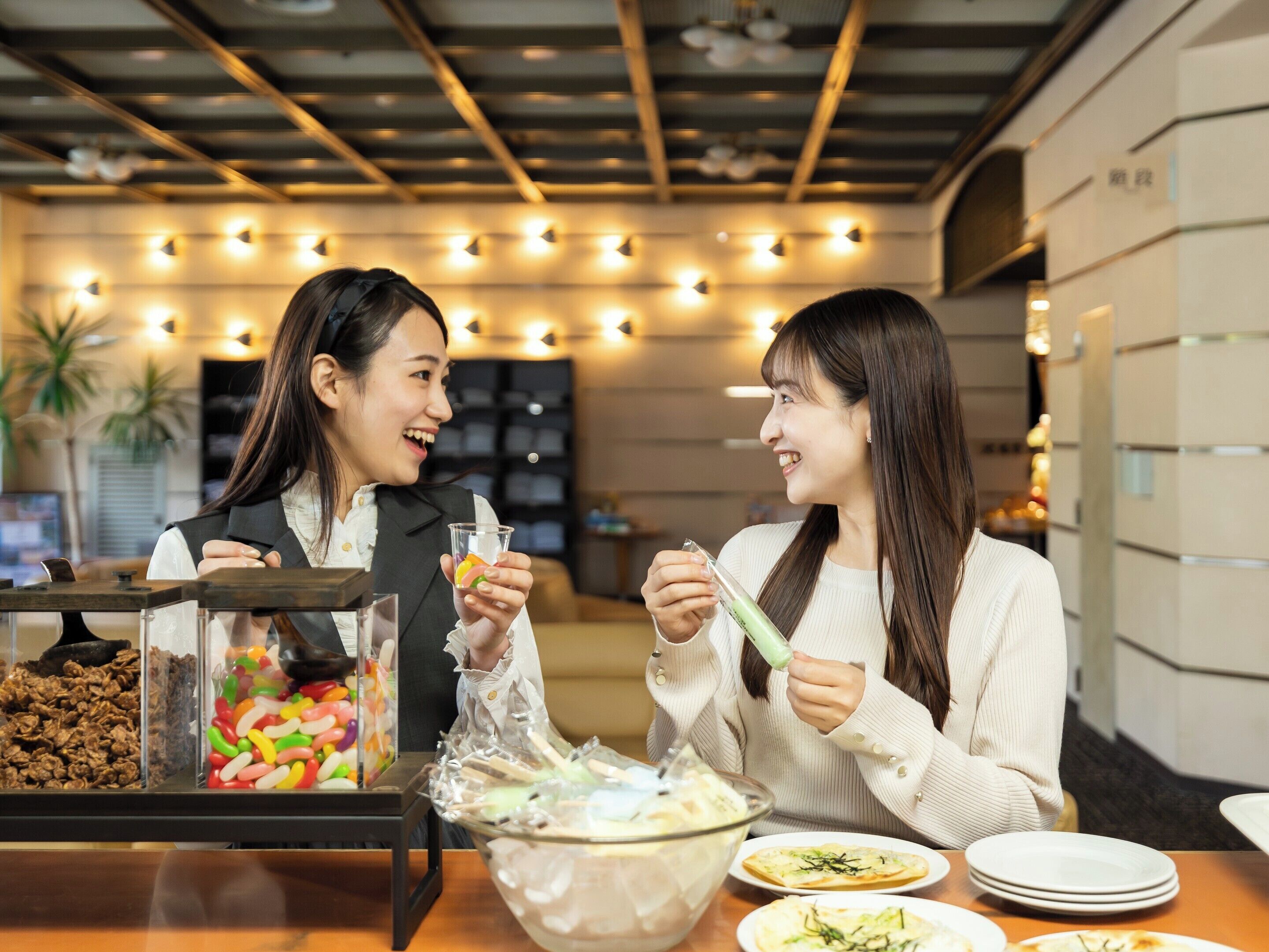 Two people dining at a table with a dessert bar in the background.