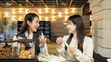 Two people dining at a table with a dessert bar in the background.