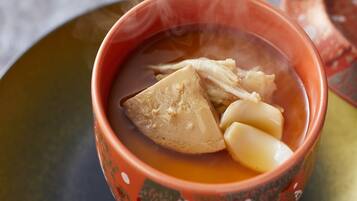 Un tazón de sopa con tapa, sobre una mesa.