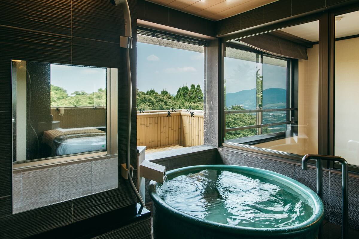 Un espace bien-être comprenant un jacuzzi, de grandes fenêtres et une vue sur l’extérieur.
