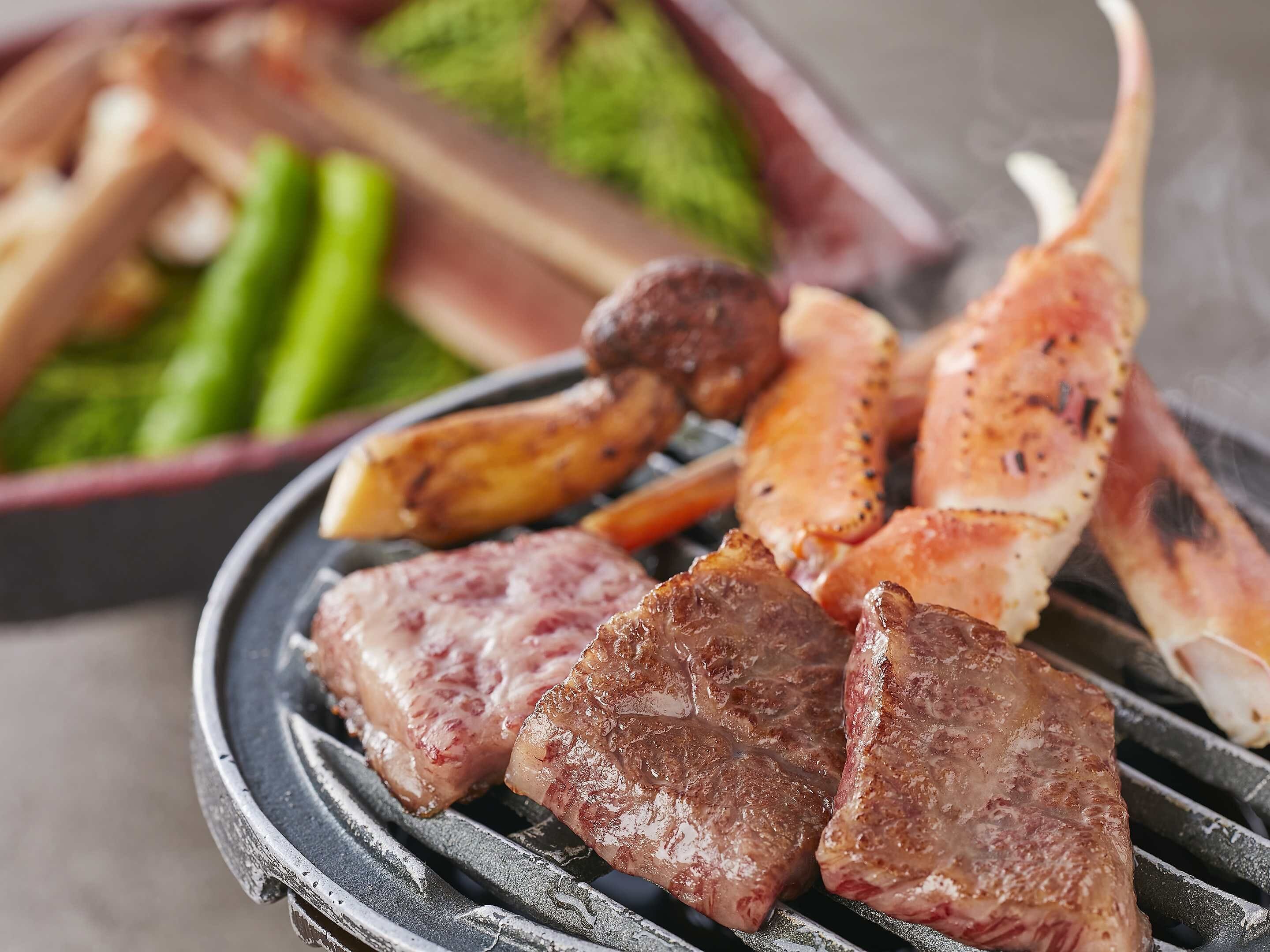 A grill with various meats and vegetables.