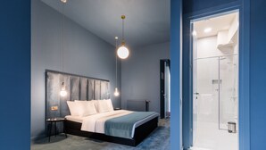 Une chambre moderne avec un grand lit, des tables de chevet et une cabine de douche en verre.