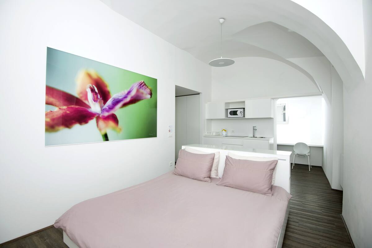 Une chambre d’hôtel moderne équipée d’un lit, d’un bureau et d’une kitchenette.
