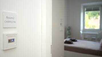 A white wall with a sign indicating "Room 2 CAMPESTRE" and a thermostat.