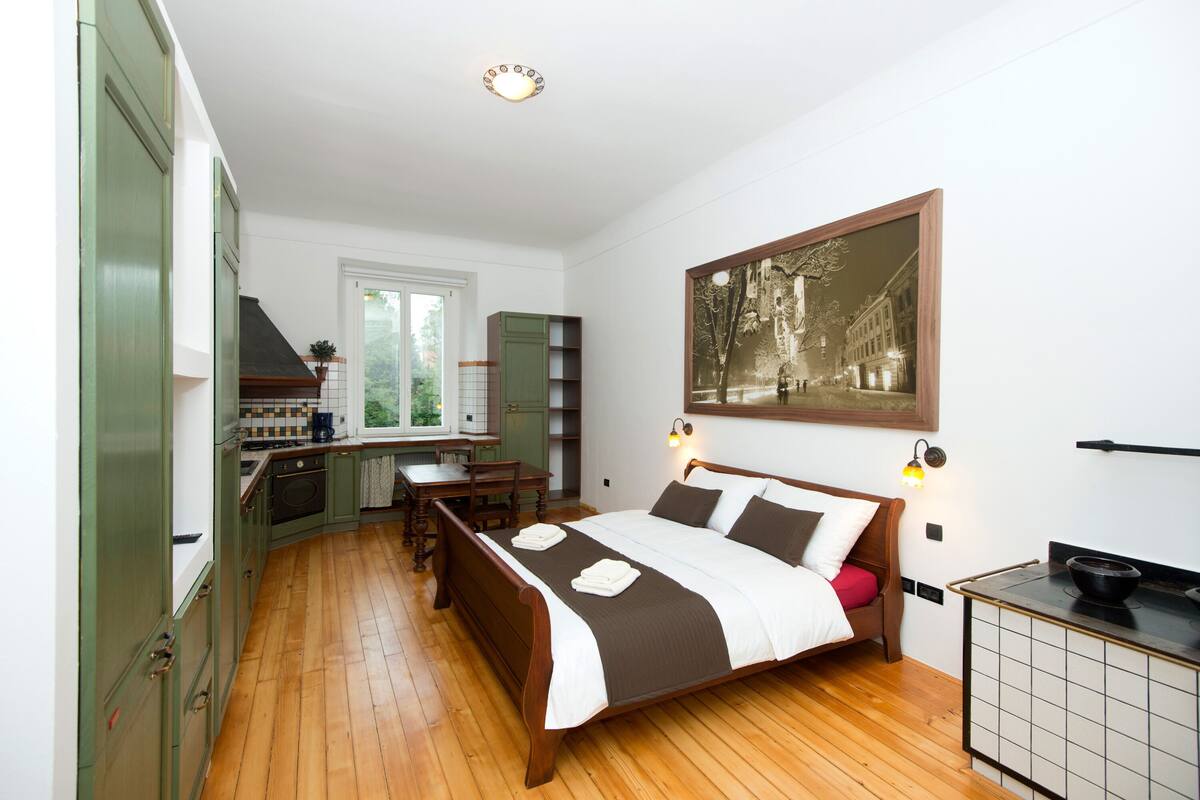 Une chambre comprenant un lit, un bureau et un coin cuisine.