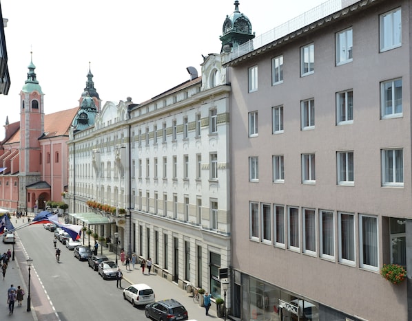 A street view with historic buildings, a church, and a modern building with a row of windows.