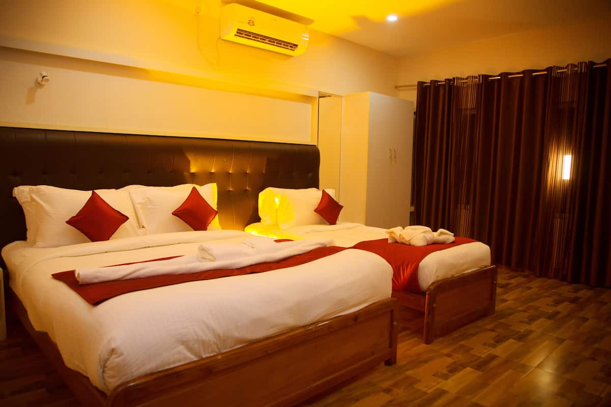 Una cama bien hecha con ropa de cama blanca y roja, un cabecero de madera y una mesita de noche.