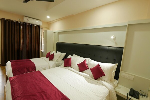 A hotel room with two beds, a dark headboard, and a bedside phone. - Hotel Wayanad Square (Mananthavady)