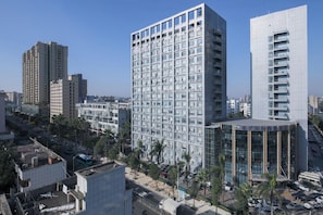 Een hoog gebouw met meerdere verdiepingen, grote ramen en een modern architectonisch ontwerp.