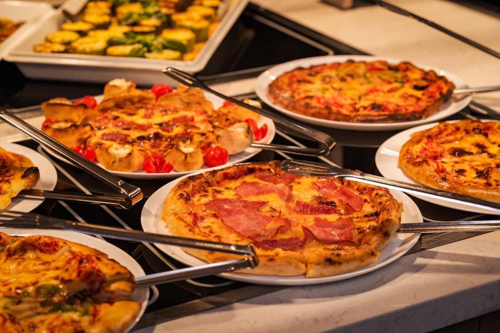 Ein Buffet mit verschiedenen Pizzen und Speisen.