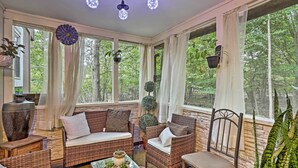 A sunroom with wicker furniture, large windows, and hanging plants. - 15 Mi to Camelback Ski Resort: Home w/ Deck! (Tobyhanna)