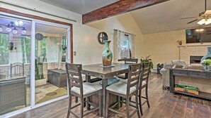 A dining area with a round table, four chairs, and a vase. There is a sliding glass door leading to a balcony with plants. - 15 Mi to Camelback Ski Resort: Home w/ Deck! (Tobyhanna)