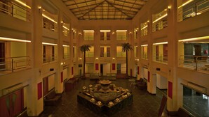 A spacious atrium with a central fountain, multiple levels, and palm trees. - Renest Gandhidham (Gandhidham)