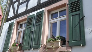 A building with multiple windows, each with green shutters and flower boxes. - Geibelhof (Karben)