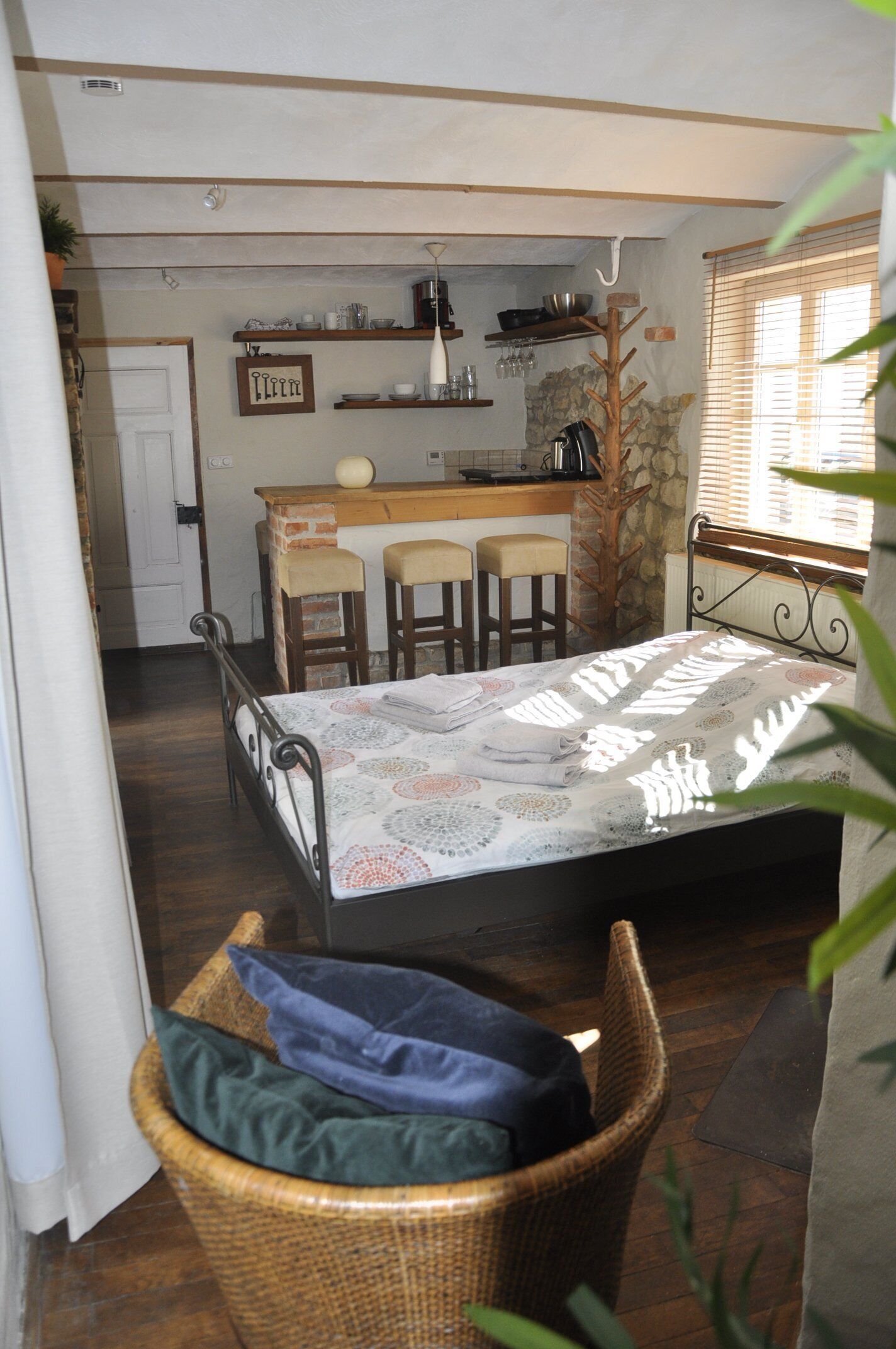 A compact room with a bed, a small kitchenette, and a dining area.