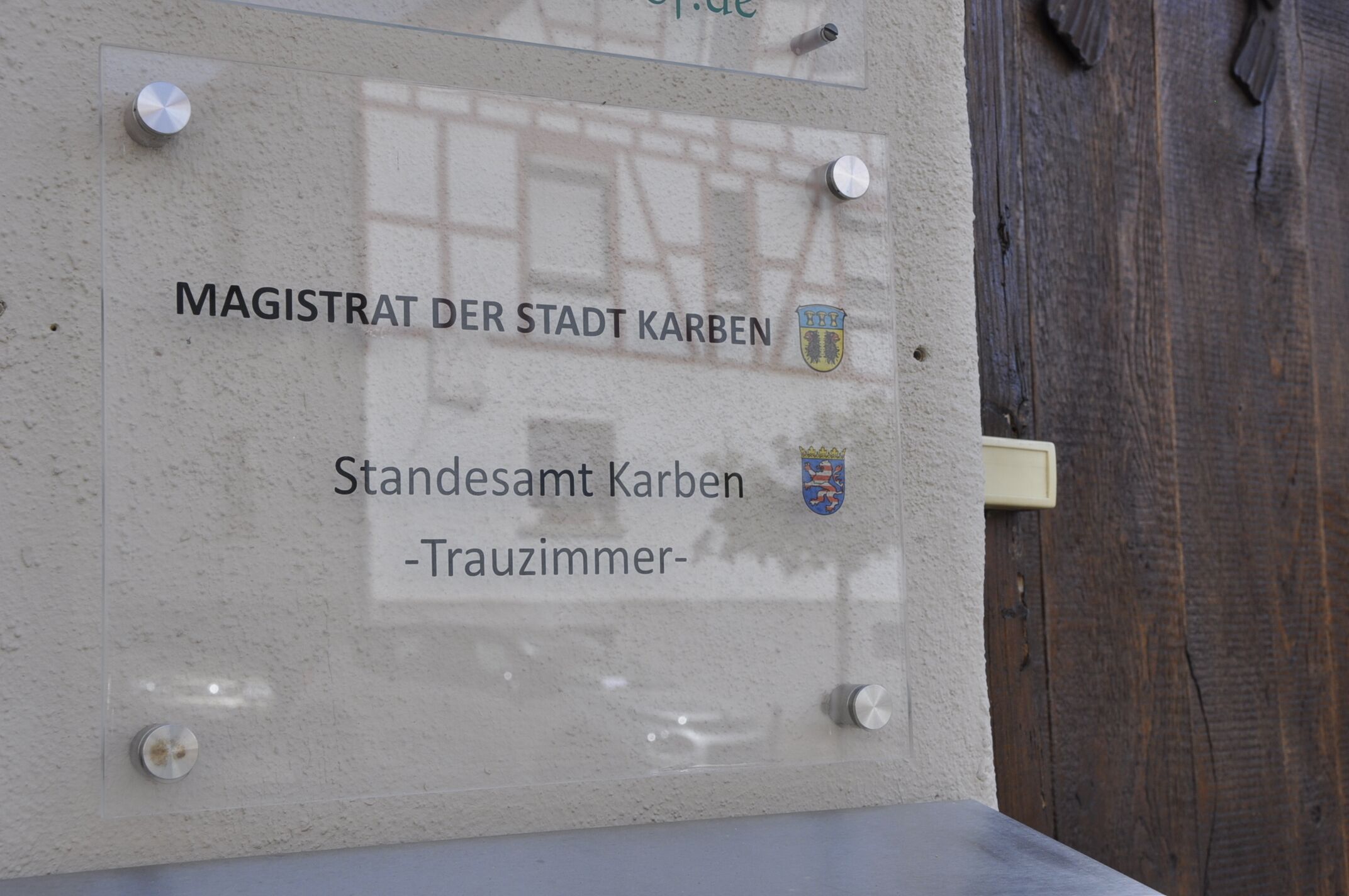 Señal con el texto 'MAGISTRAT DER STADT KARBEN' y 'Standesamt Karben - Trauzimmer-'.