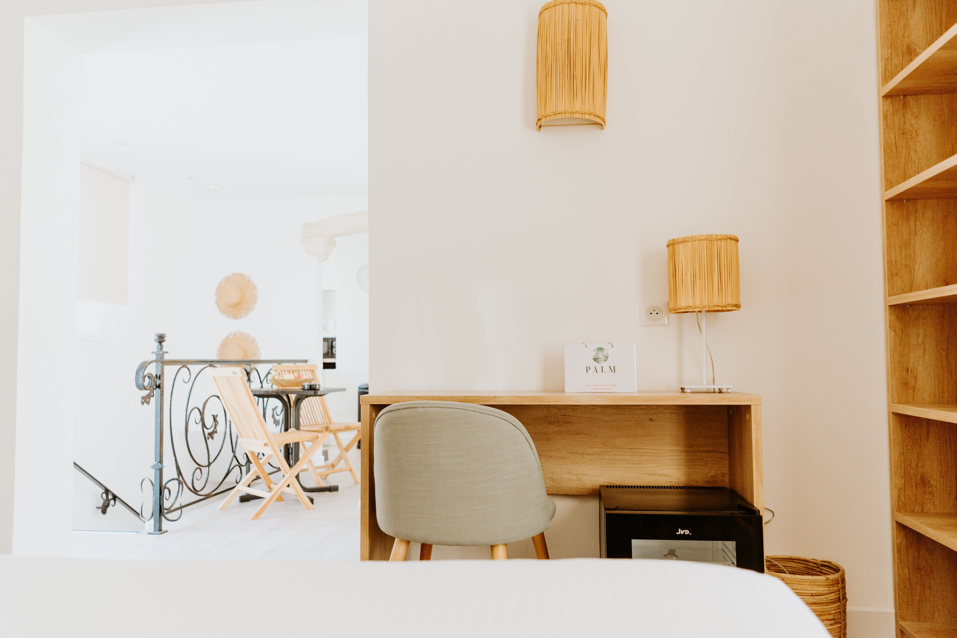 Ein schlichtes Zimmer mit Schreibtisch, Stuhl und Regalen.