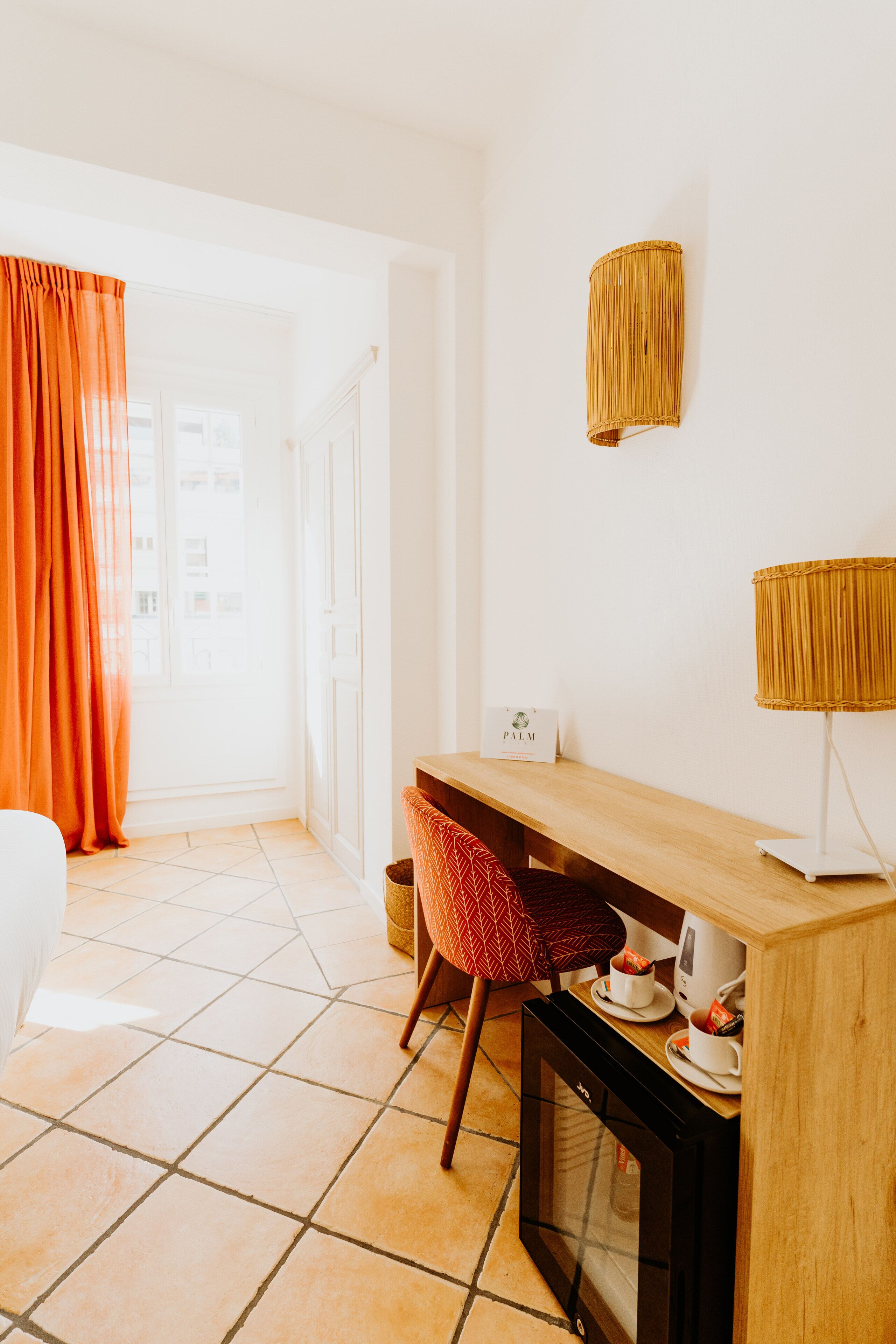 Ein Hotelzimmer mit einem Holztisch, einem Stuhl, einem Fernseher und einer Lampe.