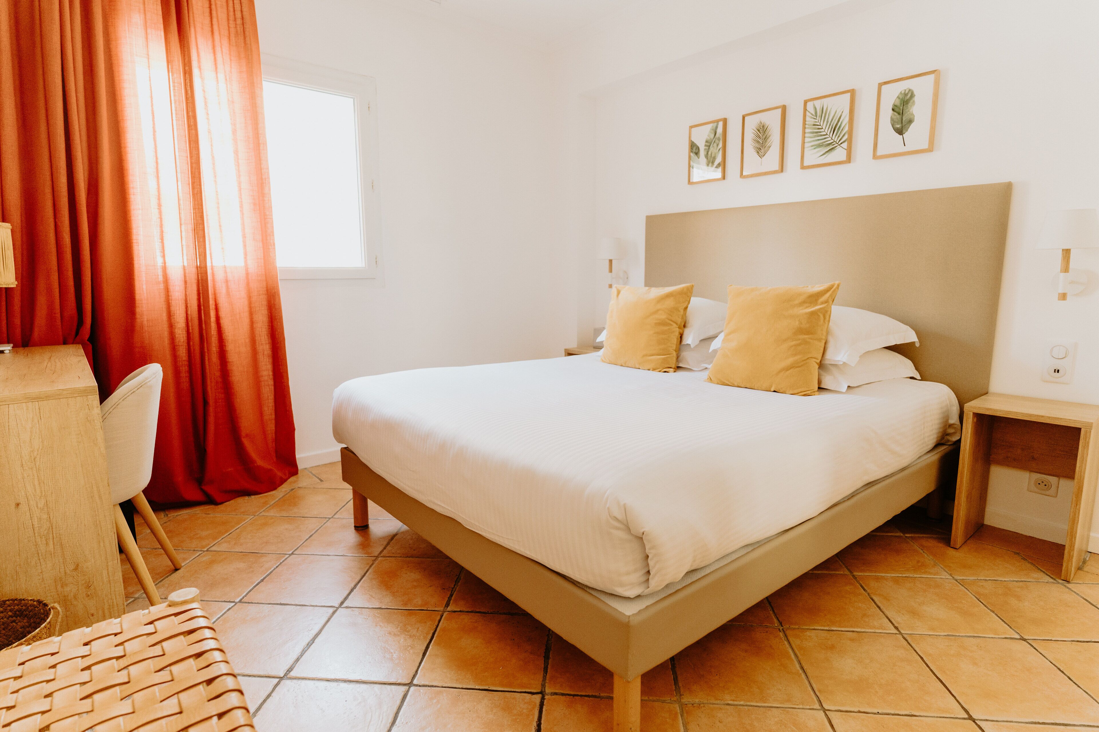 Un dormitorio ordenado con cama, mesitas de noche y una silla.