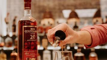 A bottle of Ron Centenario 20th Anniversary tequila being poured into a glass.