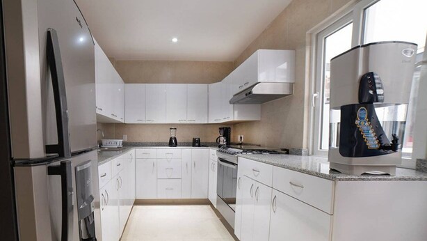 A modern kitchen with white cabinets, a built-in oven, and a coffee machine. - Comfortable apartment in Masaryk Avenue 1A (Polanco)