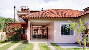A modern house with a patio, a dining area, and a small garden. - Origin Casa -2 Bedroom Beach House for up to 7 (Palhoça)