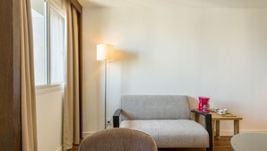 A room with a sofa, a chair, a small table with a red coffee maker, and a floor lamp. - No1712 Fantástico a Poucos Metros da Paulista! (São Paulo)