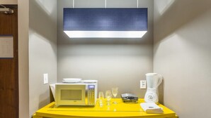 A compact kitchen with a microwave, blender, and two wine glasses on a yellow countertop. - No1712 Fantástico a Poucos Metros da Paulista! (São Paulo)