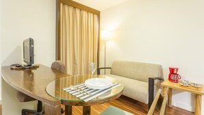 A hotel room with a glass-top dining table, a sofa, a TV, a lamp, and a coffee maker. - No1712 Fantástico a Poucos Metros da Paulista! (São Paulo)