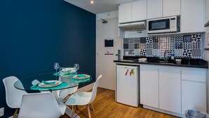 A compact kitchen with white cabinets, a microwave, and a patterned backsplash. - Ad404 Stylish Apartment in the Best Part of Itaim (São Paulo)