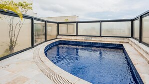 A rooftop swimming pool with glass walls and a tiled deck. - Ad604 Estúdio a 1 Quadra da Av. Paulista (São Paulo)