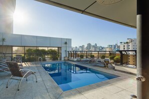A rooftop pool with lounge chairs and a city view. - Ce806 Flat Para 1 ou 2 Pessoas nos Jardins! (São Paulo)