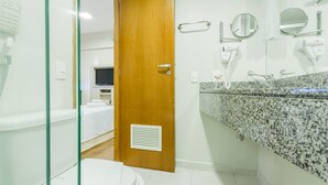 A modern bathroom with a granite countertop, a wooden door, and a white toilet. - Me1211 Próximo à Paulista, na Bela Vista (São Paulo)