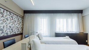 A hotel room with two beds, a desk, and a large window with sheer curtains. - Me1211 Próximo à Paulista, na Bela Vista (São Paulo)