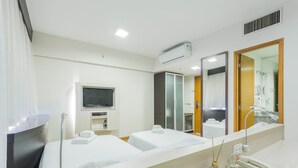A hotel room with two beds, a TV, a minibar, a bathroom with a mirror, and a telephone. - Me1211 Próximo à Paulista, na Bela Vista (São Paulo)