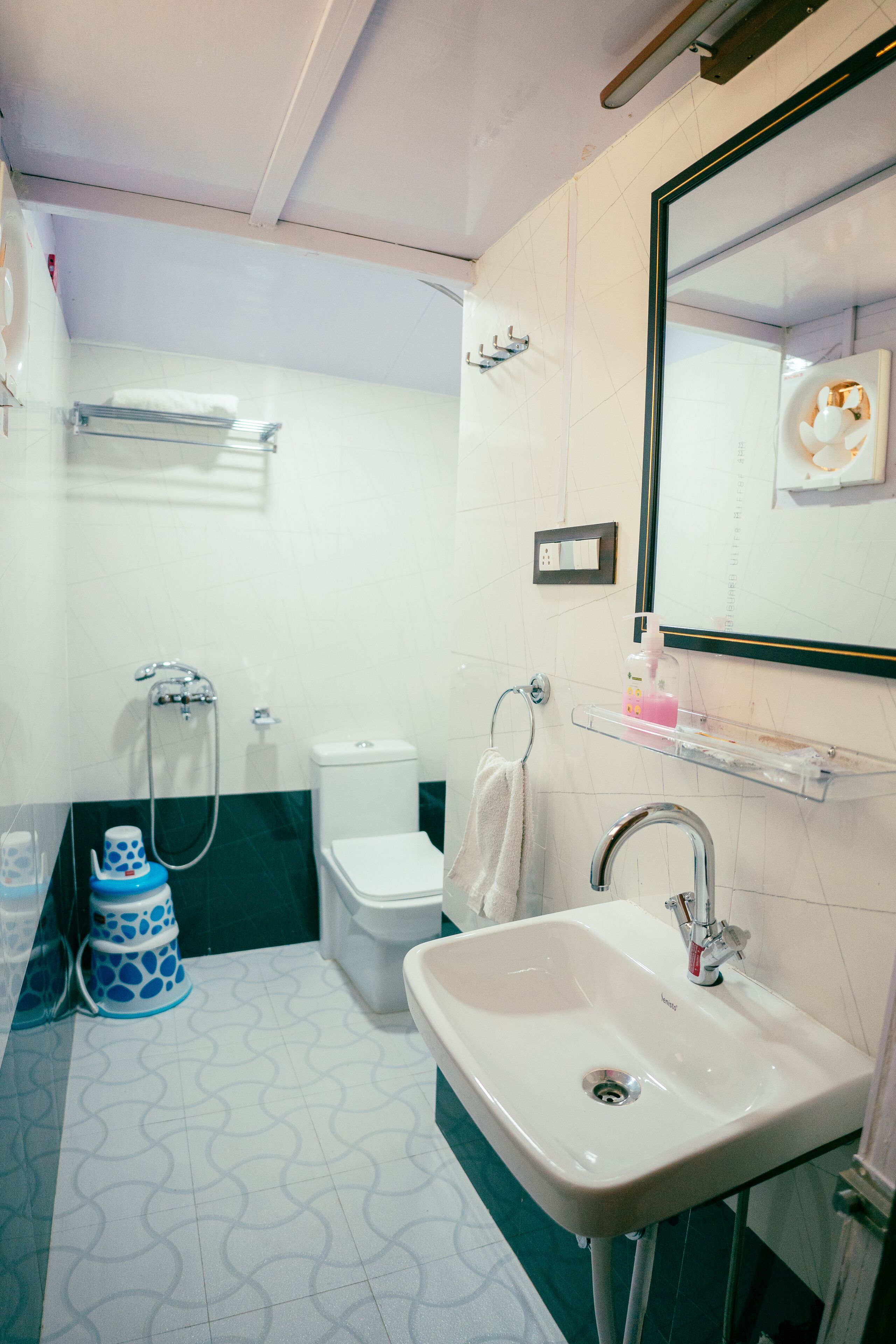 A bathroom with a white sink, a mirror, a toilet, and a shower.