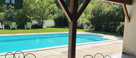 Een seizoensgebonden buitenzwembad en parasols bij het zwembad