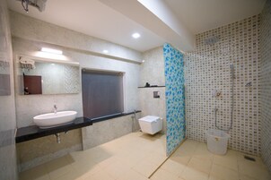Un baño moderno con un lavamanos grande, espejo y zona de ducha.