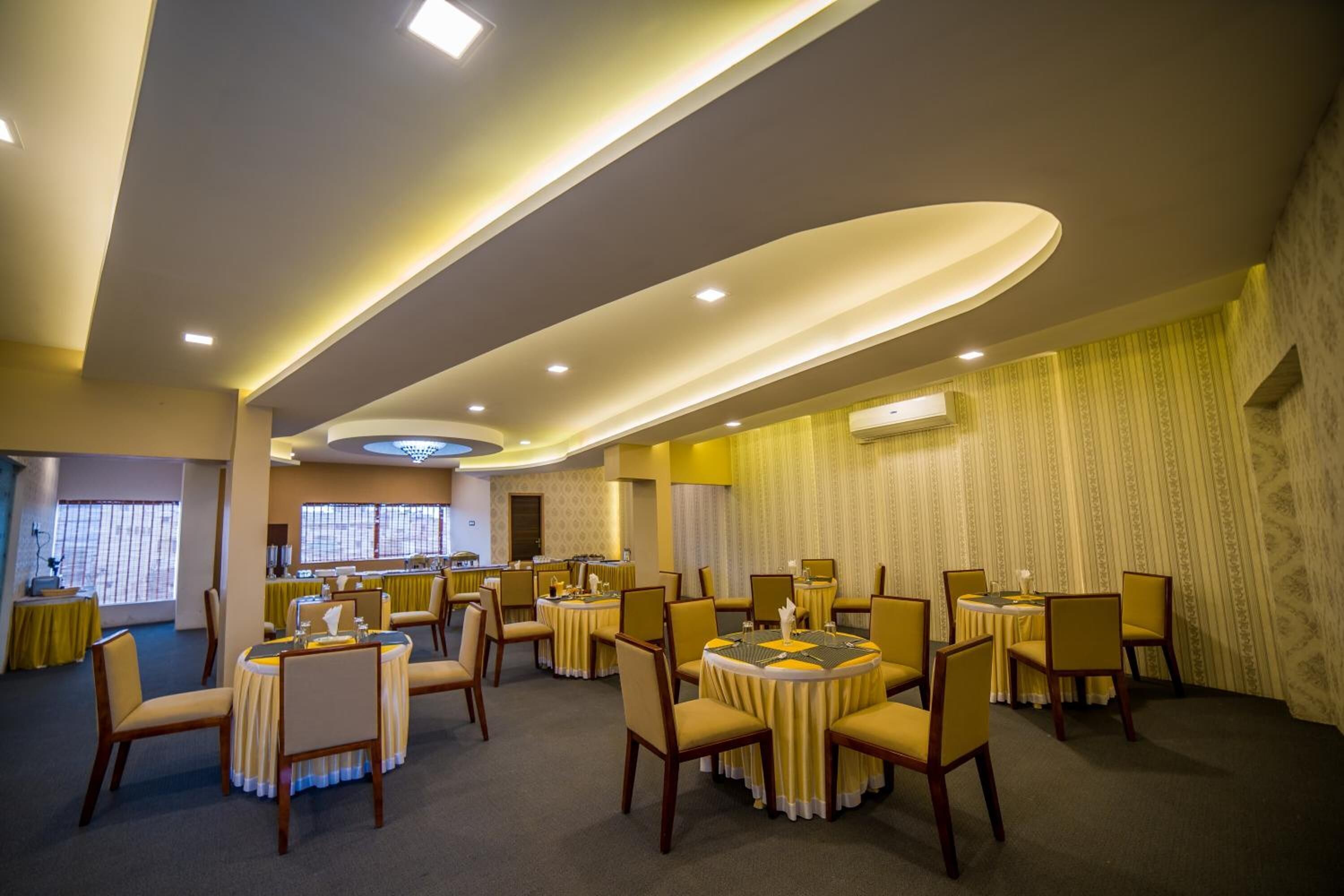 A conference room with multiple round tables and chairs, equipped with nameplates and table settings.