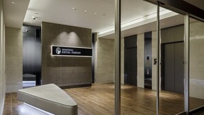 A modern hotel lobby with a reception desk, a seating area, and a glass partition wall. - Shizutetsu Hotel Prezio Tokyo Tamachi (Tokyo)