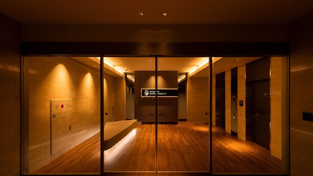 A hotel lobby with a wooden floor, glass doors, and a sign indicating the direction to the lobby. - Shizutetsu Hotel Prezio Tokyo Tamachi (Tokyo)