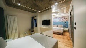 Ein Hotelzimmer mit Bett, Fernseher, kleinem Tisch und Stuhl.